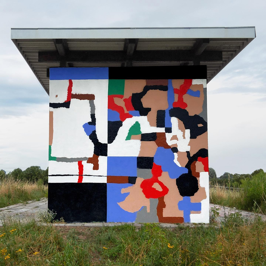 Foto einer bemalten Wand im Grünen, mit flachem Dach darüber